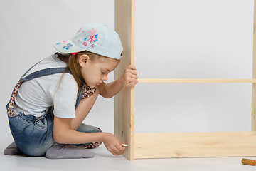 Image showing Little girl in overalls collector furniture screw spins
