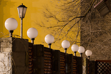 Image showing number of street lights on the fence in evening