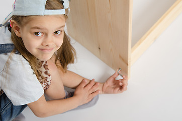 Image showing Girl in overalls collector furniture screw spins