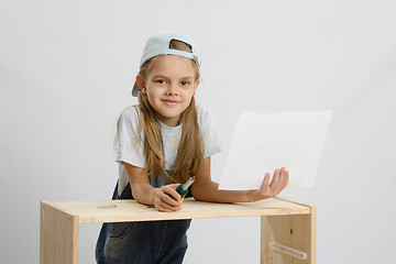 Image showing Girl-collector of furniture with a screwdriver and drawing collects furniture