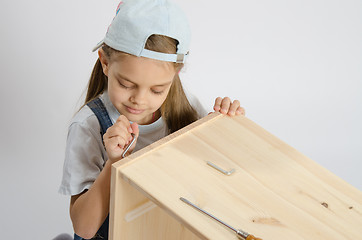 Image showing Little girl in the image of garbage furniture screw spins