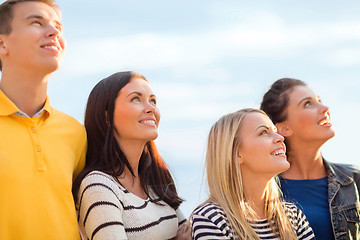 Image showing group of happy friends looking up on beach