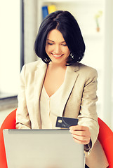 Image showing happy woman with laptop computer and credit card