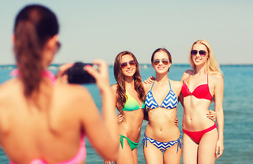 Image showing group of smiling women photographing on beach