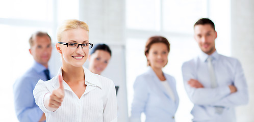 Image showing businesswoman in office showign thumbs up