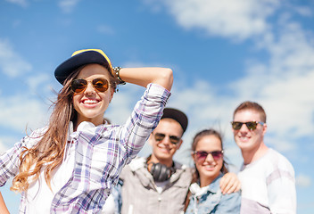 Image showing teenage girl with headphones and friends outside