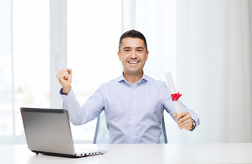 Image showing smiling man with diploma and laptop at office