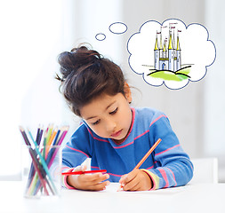 Image showing happy little girl drawing castle with crayons