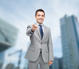 Image showing happy smiling businessman in suit pointing at you