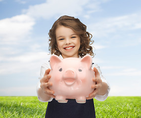 Image showing happy girl holding piggy bank 