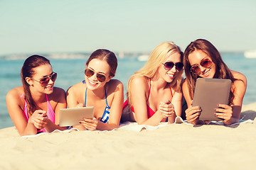 Image showing group of smiling young women with tablets on beach