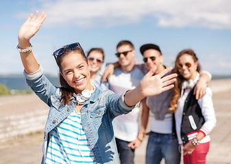 Image showing teenage girl with headphones and friends outside