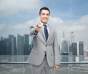 Image showing happy smiling businessman in suit pointing at you