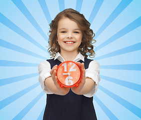 Image showing happy girl with alarm clock over blue 