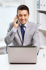 Image showing smiling businessman with laptop and smartphone