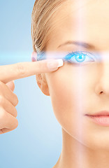 Image showing beautiful woman pointing to eye