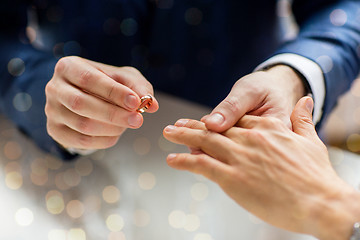 Image showing close up of male gay couple hands and wedding ring