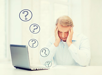 Image showing stressed old man filling a form at home