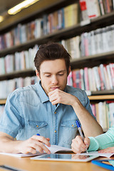 Image showing male student with tablet pc networking in library