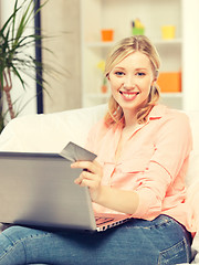 Image showing happy woman with laptop computer and credit card