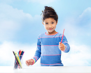 Image showing happy little girl drawing with coloring pencils