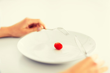 Image showing woman with plate and one tomato