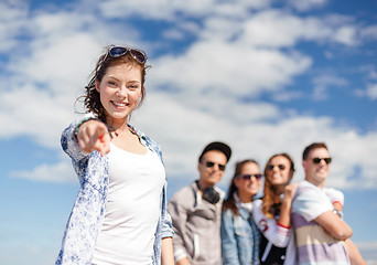 Image showing teenage girl with headphones and friends outside