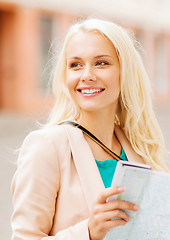 Image showing girl looking into tourist map in the city