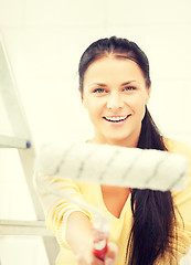 Image showing happy young woman with paintroller