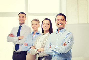 Image showing smiling businessman in office with team on back