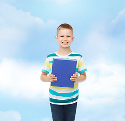 Image showing smiling little student boy with blue book