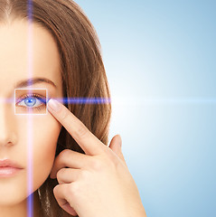 Image showing beautiful woman pointing to eye