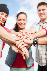 Image showing teenagers hands on top of each other outdoors