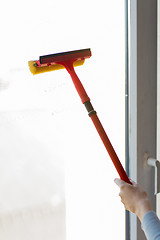 Image showing close up of hand cleaning window with sponge