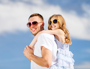 Image showing happy father and child in sunglasses over blue sky