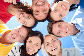 Image showing smiling friends in circle on summer beach