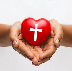 Image showing female hands holding heart with cross symbol