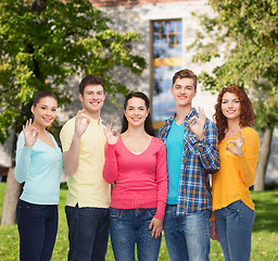 Image showing group of smiling teenagers over campus background