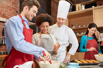 Image showing happy friends and chef cook baking in kitchen