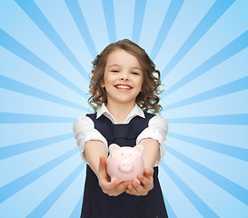 Image showing happy girl holding piggy bank on palms