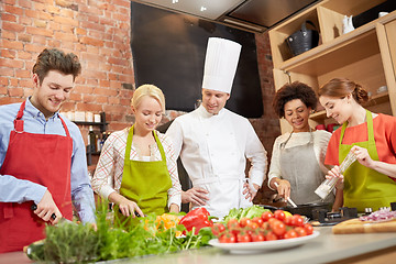 Image showing happy friends and chef cook cooking in kitchen