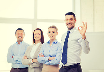 Image showing smiling businessman showing ok-sign in office