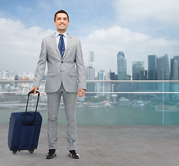 Image showing happy businessman in suit with travel bag