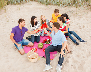 Image showing group of happy friends having picnic on beach