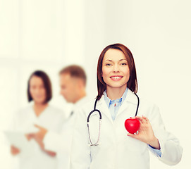 Image showing smiling female doctor with heart and stethoscope