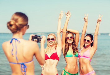 Image showing group of smiling women photographing on beach