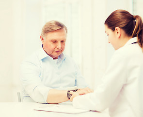 Image showing female doctor or nurse measuring blood pressure