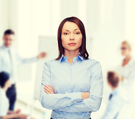 Image showing smiling businesswoman with crossed arms at office