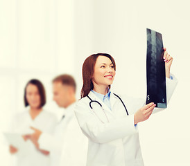 Image showing smiling female doctor looking at x-ray