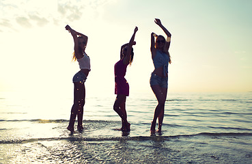 Image showing happy female friends dancing on beach